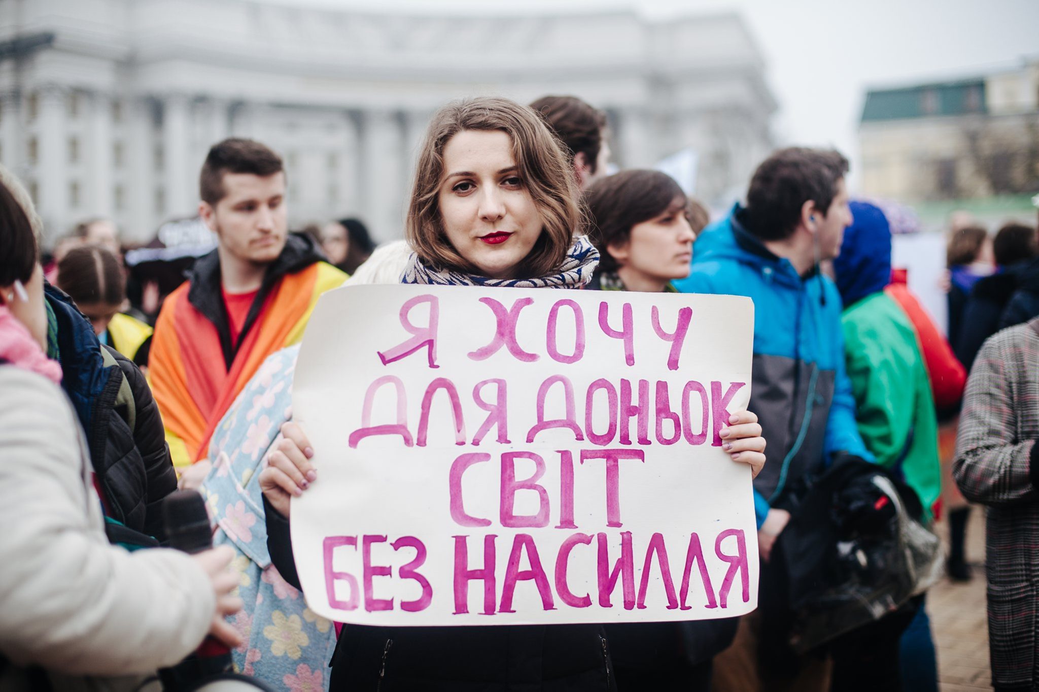 жінка тримає плакат проти насильства